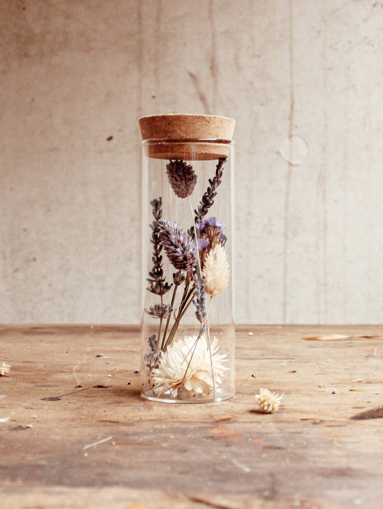 Droogbloemen in glas met een dop van kurk